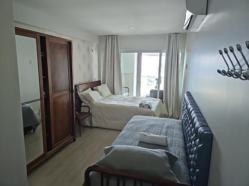ein Schlafzimmer mit einem Sofa, einem Bett und einem Fenster in der Unterkunft Ap70 m2 condomínio luxo Costa Espanha- Salvador- pré Carnaval -Réveillon em praia exclusiva- Vista Mar in Salvador