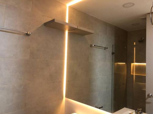 La salle de bains est pourvue d'un lavabo et d'une douche éclairée. dans l'établissement Aparta estudio en Chia con la mejor vista, à Chía
