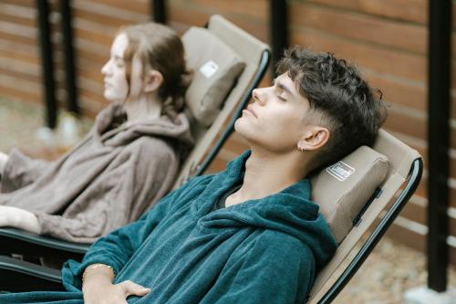 two young people sitting in chairs with their backs to each other at log&sauna 和 - nagomi, wakayama - in Kinokawa