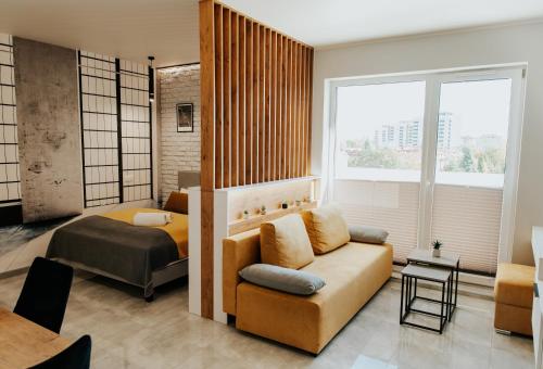 un salon avec un canapé et un lit dans l'établissement Apartamenty Czestochowa Eu 'garaż gratis', à Częstochowa