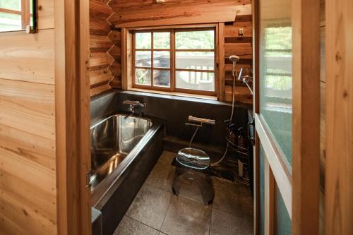 a bathroom with a tub and a sink at log&sauna 和 - nagomi, wakayama - in Kinokawa