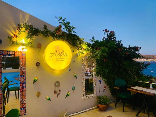 un ristorante con un cartello giallo sul lato di un muro di Aden Boutique Otel a Çeşme