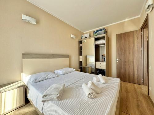 a bedroom with a large bed with towels on it at Apartment Rimma in Batumi