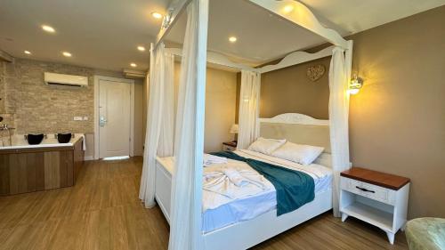 una camera con letto a baldacchino e un bagno di Aden Boutique Otel a Çeşme