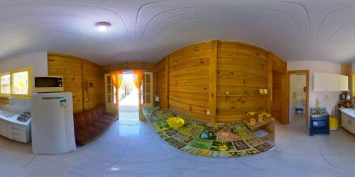 a large kitchen with a large wooden wall at Residencial Álacre casa e cabana aluguel Ferrugem SC in Garopaba
