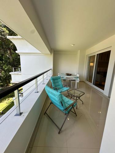a balcony with a blue chair and a table at Green Park hermoso apartamento vista al lago in Punta del Este