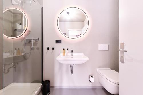 a white bathroom with a sink and a mirror at XZLLENZ Küche Bad S-Bahn Parken Smart-TV Wellbeing in Neunkirchen am Sand