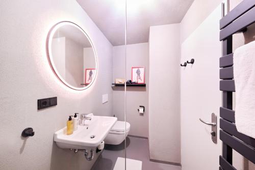 a white bathroom with a sink and a mirror at XZLLENZ Küche Bad S-Bahn Parken Smart-TV Wellbeing in Neunkirchen am Sand