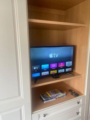 a flat screen tv in a book shelf at Quaint Cottage main street Llandeilo in Llandeilo