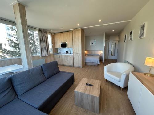 a living room with a blue couch and a room at Primavera Premium Sierra Nevada 4 in Sierra Nevada