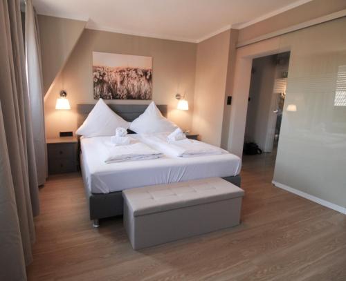 a bedroom with a large bed with white sheets at La Bella Vita in Emden