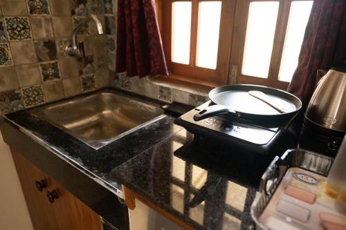 a kitchen with a sink and a pan on a stove at Vistar Holidays in Goa