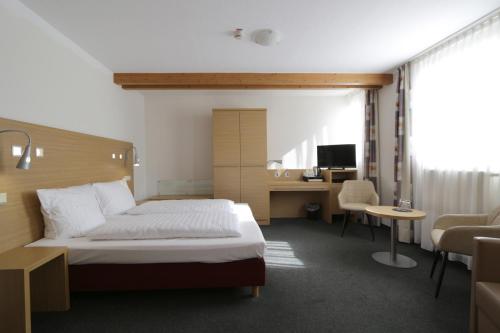 ニュームブレヒトにあるKaspers Gästehausのベッドとパソコン付きの机がある寝室