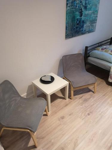 a room with two chairs and a table and a bed at Alicante privat room 5min walk from Railstation in Koblenz