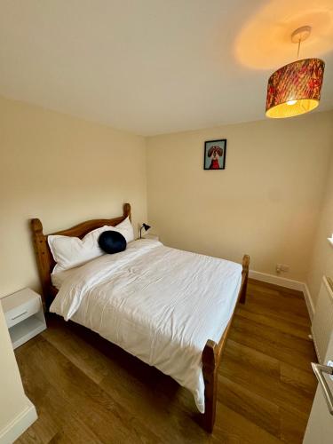 a bedroom with a bed with a white bedspread at Florina s House 4 Bedrooms Villa in Rugeley