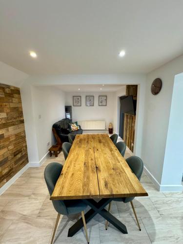 a dining room with a wooden table and chairs at Florina s House 4 Bedrooms Villa in Rugeley