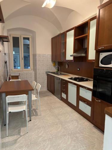a kitchen with wooden cabinets and a table and chairs at Casa Luna in Ventimiglia