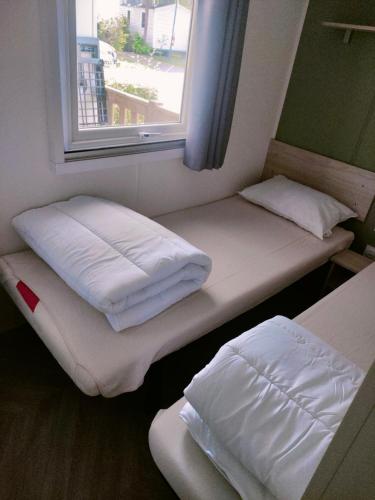 deux lits assis dans une pièce avec une fenêtre dans l'établissement Mobil home, camping 4* Lac privé, à Gastes