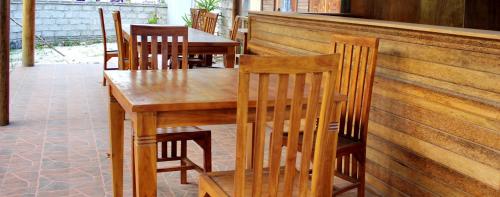 un tavolo e sedie in legno presso un ristorante di Surya Home Stay a Nusa Lembongan