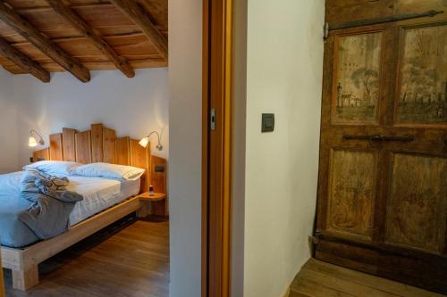 a bedroom with a bed and a wooden door at Agriturismo Cà Gianin in Vervio