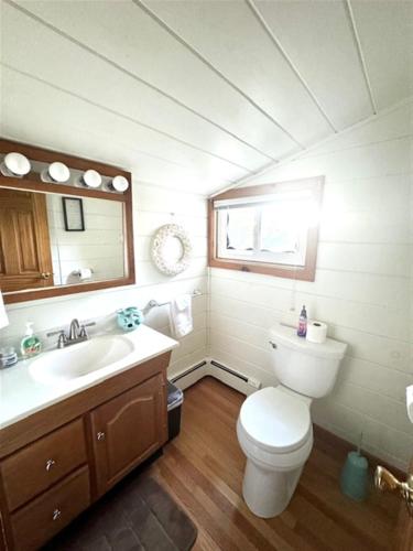 a bathroom with a toilet and a sink and a mirror at ANNABESSACOOK RETREAT LIMIT 8 home in Winthrop