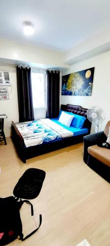 a bedroom with a bed and a chair in it at Staycation in Quezon City in Manila