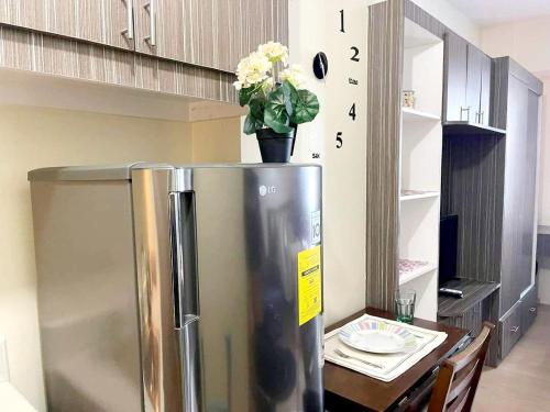 a stainless steel refrigerator in a kitchen with a table at Staycation in Quezon City in Manila