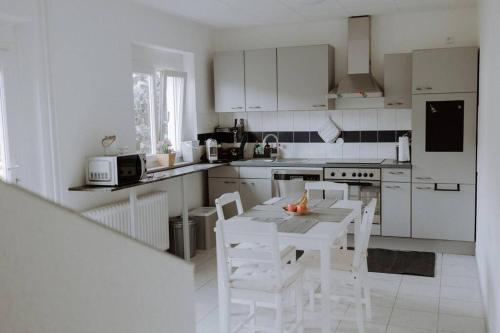 a white kitchen with a table and chairs in it at Ferienwohnung Maria in Herten