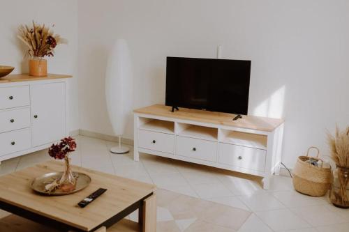 a living room with a television on a white dresser at Ferienwohnung Maria in Herten