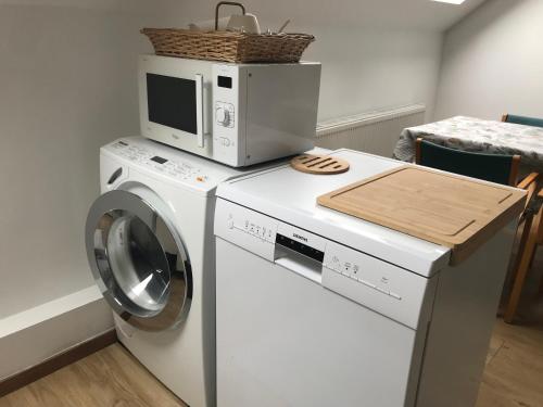 a washer and dryer with a microwave on top of it at Appartement lumineux - Bruxelles in Brussels