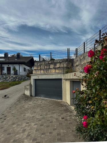 a parking lot with a garage with a fence and roses at Große Wohnung mit Bergblick in Frasdorf
