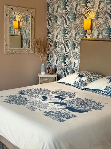 a bedroom with a bed with a blue and white blanket at Le Clos du Pontet in Orliénas