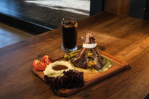 een bord eten op een houten tafel met een drankje bij Yeldeğirmeni Konuk Evi in Istanbul