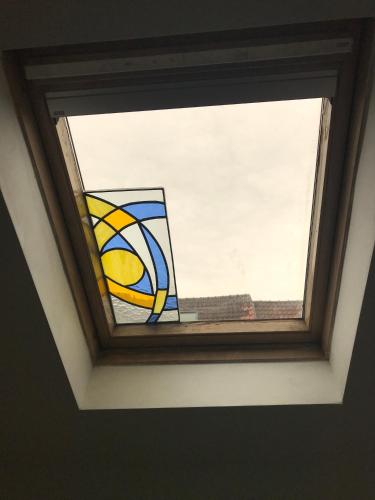 a window in a room with a stained glass window at Appartement lumineux - Bruxelles in Brussels