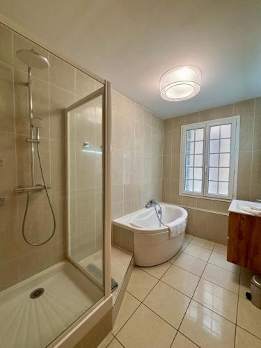 une salle de bain avec une douche, une baignoire et un lavabo dans l'établissement Mermoz Vue Mer, Parking, à Deauville