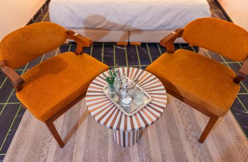 a table with two chairs and a plate with a vase at Riad L'ECOLE in Marrakech