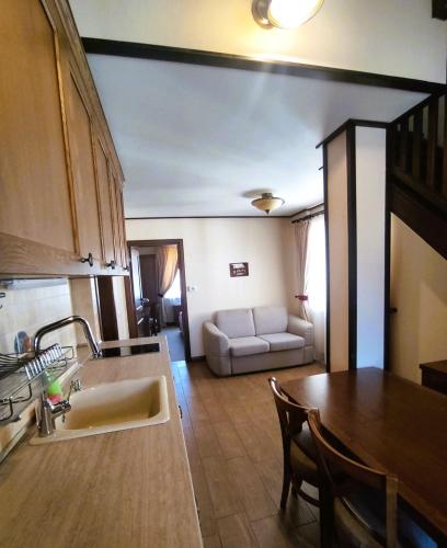 a kitchen and living room with a table and a couch at 7 Pools SPA Boutique Hotel in Bansko