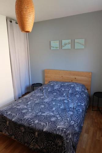 une chambre avec un lit avec une couette bleue dans l'établissement PORT LA FORET T2 avec jardin 300m de la plage, à La Forêt-Fouesnant