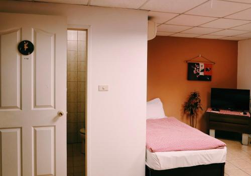 a small bedroom with a bed and a bathroom at Puli Islet Inn in Puli