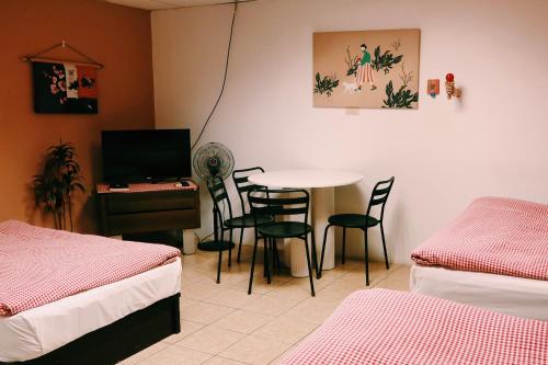 a room with two beds and a table and chairs at Puli Islet Inn in Puli
