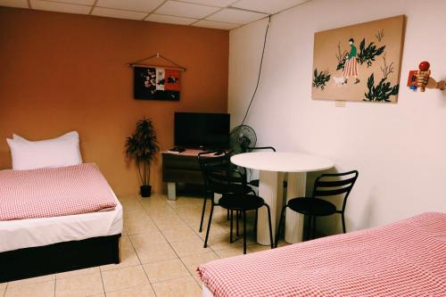 a room with two beds and a table and a desk at Puli Islet Inn in Puli