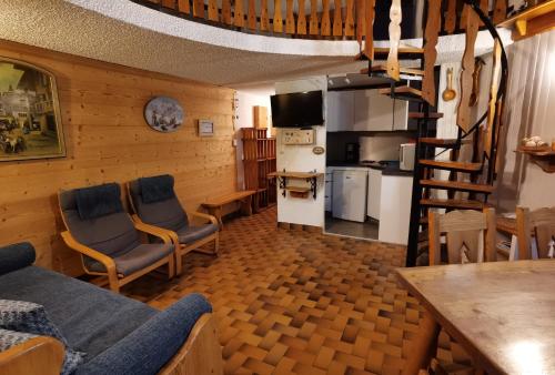 Il comprend un salon avec deux chaises et une cuisine. dans l'établissement MyHome - Génépis 33 - 4 pax skis aux pieds - Val Claret, à Tignes