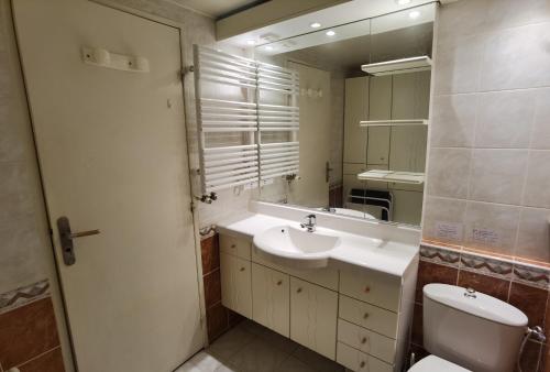 une salle de bain avec un lavabo, des toilettes et un miroir dans l'établissement MyHome - Génépis 33 - 4 pax skis aux pieds - Val Claret, à Tignes