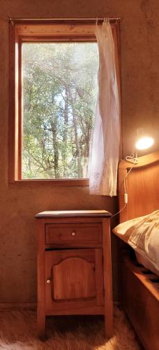 a bedroom with a bed and a table with a window at Casa de montaña in Golondrinas