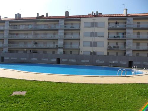 an empty swimming pool in front of a building at Alojamentos Campo & Mar - T1 com Piscina in São Martinho do Porto