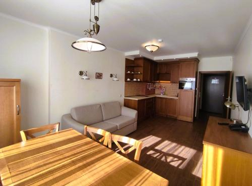 a kitchen and living room with a table and a couch at 7 Pools SPA Boutique Hotel in Bansko
