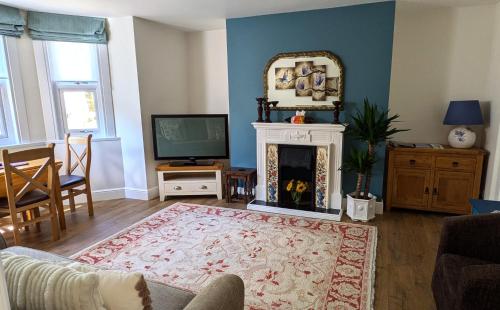 a living room with a fireplace and a tv at Park Avenue Stop in Dover