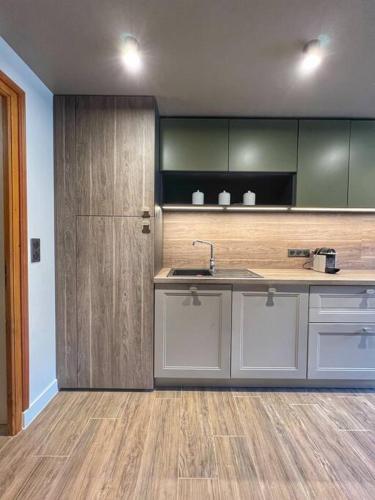 une cuisine avec un évier et un réfrigérateur dans l'établissement Megève appartement centre ville palais des sports, à Megève