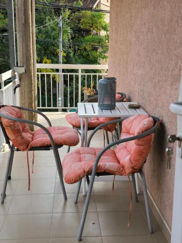 a table and chairs on a balcony with a window at Smestaj Dzentlmen in Soko Banja