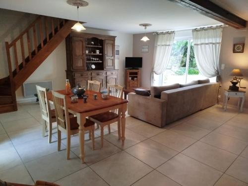 a living room with a table and a couch at La Ferme d' Emerentine in Bacilly